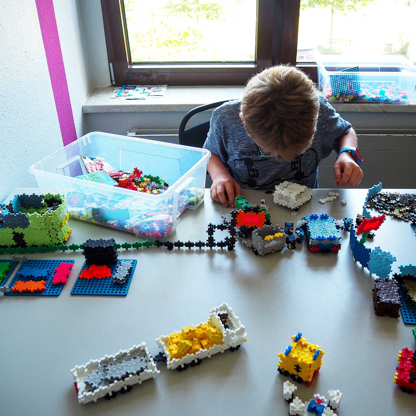 Ein Kind baut mit 3D-Puzzle Autos und Häuser.