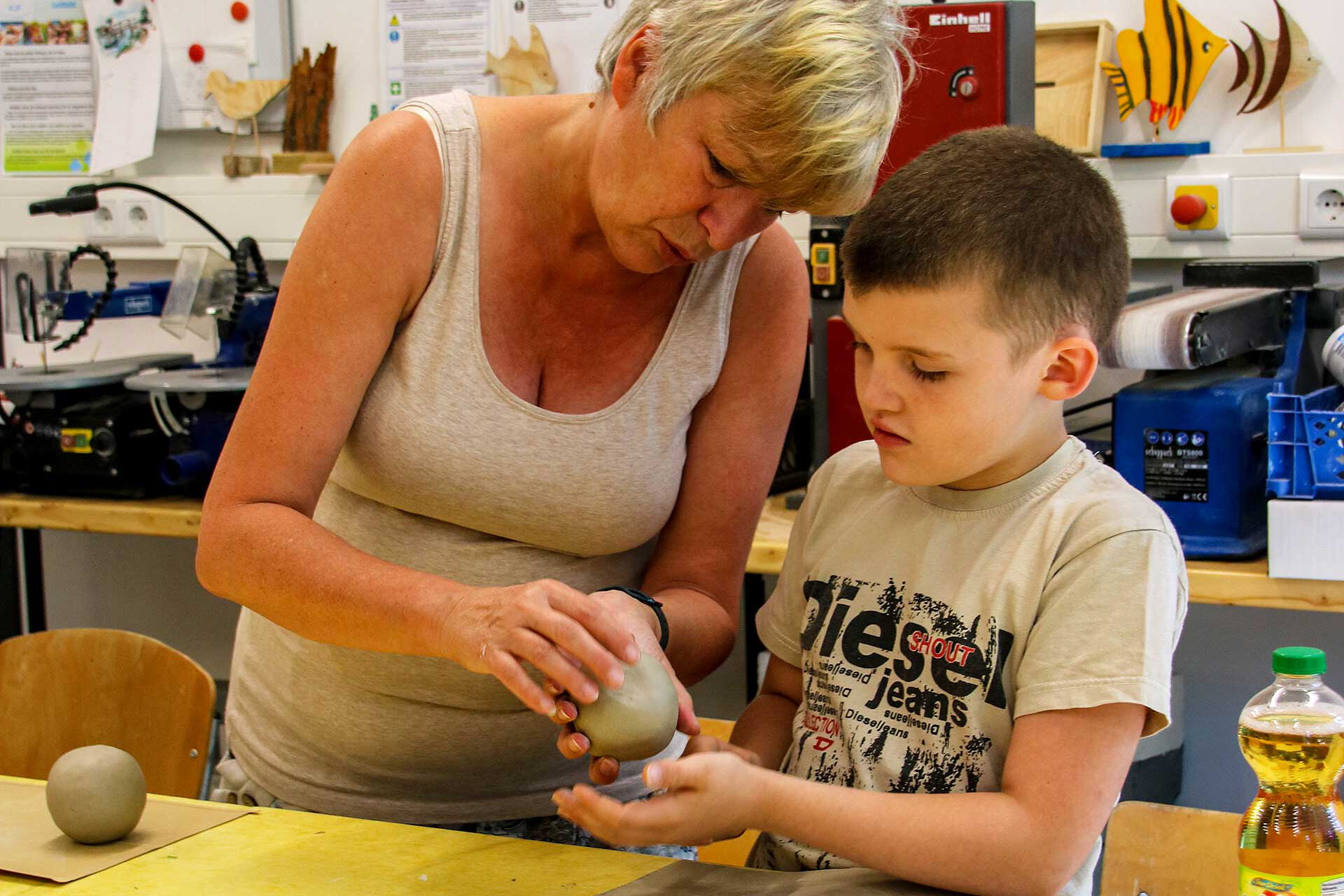 Ein Kind bearbeitet Ton in der Keramikwerkstatt.
